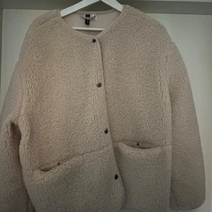 Beige Teddyjacka från H&M - Så fin och populär Begie Teddyjacka från H&M🤍 Köpt för ca 3 veckor sedan och använd 2 gånger så den är i nyskick! I storlek L men jag brukar ha s-m i jackor så denna är ganska liten i storleken❣️