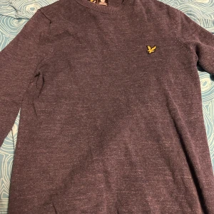 Mörkblå tröja från Lyle & Scott - Säljer en snygg mörkblå tröja från Lyle & Scott. Den har en broderad gul logga på bröstet och är i ett mjukt material. Perfekt för både vardag och lite finare tillfällen. Tröjan har långa ärmar, hör av er för frågor 