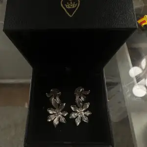 Snygga silverfärgade örhängen i form av blommor. De har en elegant och glittrig yta som fångar ljuset fint. Perfekta för att ge en extra touch till din outfit, oavsett om det är för en fest eller en speciell kväll. Sterling silver!!