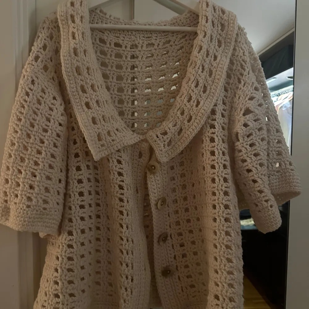 Mysig beige stickad kofta med stora knappar framtill. Den har en luftig design med trekvartsärmar och en bred krage. Perfekt för en avslappnad stil hemma eller en sval sommarkväll. 🧶✨. Tröjor & Koftor.