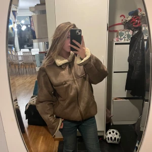Jacka från Urban outfitters - Säljer en snygg brun mockajacka med mysigt teddyfoder. Jackan har dragkedja och en cool vintage-look. Perfekt för höst och vinter, håller dig varm och stilren. Passar till både vardag och fest! Storlek M.