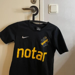 Svart AIK fotbollströja från Nike - Säljer en svart AIK fotbollströja från Nike i Dri-Fit material. Tröjan har korta ärmar och AIK-loggan på bröstet. Perfekt för unga AIK-fans! 🖤Tröjan är i barnstorlek M ( 137 - 147 ) 10-12 YRS.