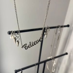 Silverhalsband med texten 'Believe' - Snyggt silverhalsband med texten 'Believe' i ett elegant typsnitt. Perfekt för att ge en touch av inspiration till din outfit. Kedjan är tunn och smidig, vilket gör den lätt att bära varje dag. Passar både till vardags och festliga tillfällen.