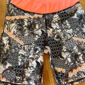 Mönstrade träningsshorts - Säljer ett par coola träningsshorts från OTD. De har ett unikt mönster med blommor och geometriska former i svart, vitt och orange. Perfekta för sommarens träningspass! 🏃‍♂️