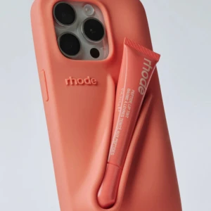 Rhode mobilskal - Intressekoll på mitt mobilskal från rhode! Väldigt svåra att få tag på, färgen Peach pit till iPhone 15 pro Max! Skalet är som nytt och har kvar orginalförpackning. Priset är endast för mobilskalet och inte för läppglanset! Andra och tredje bilden är mina egna!