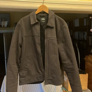 Workwear jacka Zara - Säljer en stilren svart jacka från Zara i storlek L. Jackan har en klassisk design med dragkedja och är perfekt för höst och vår. 