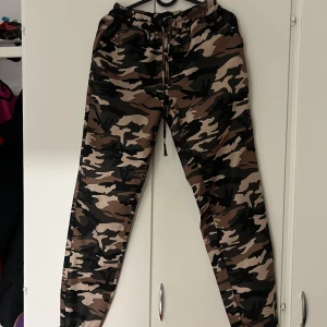 Camouflage cargopants - Säljer ett par snygga camouflage cargopants med snörning. Perfekta för en avslappnad stil eller utomhusaktiviteter. Byxorna har en loose passform och är i mycket bra skick. Passar perfekt för höst och vår!