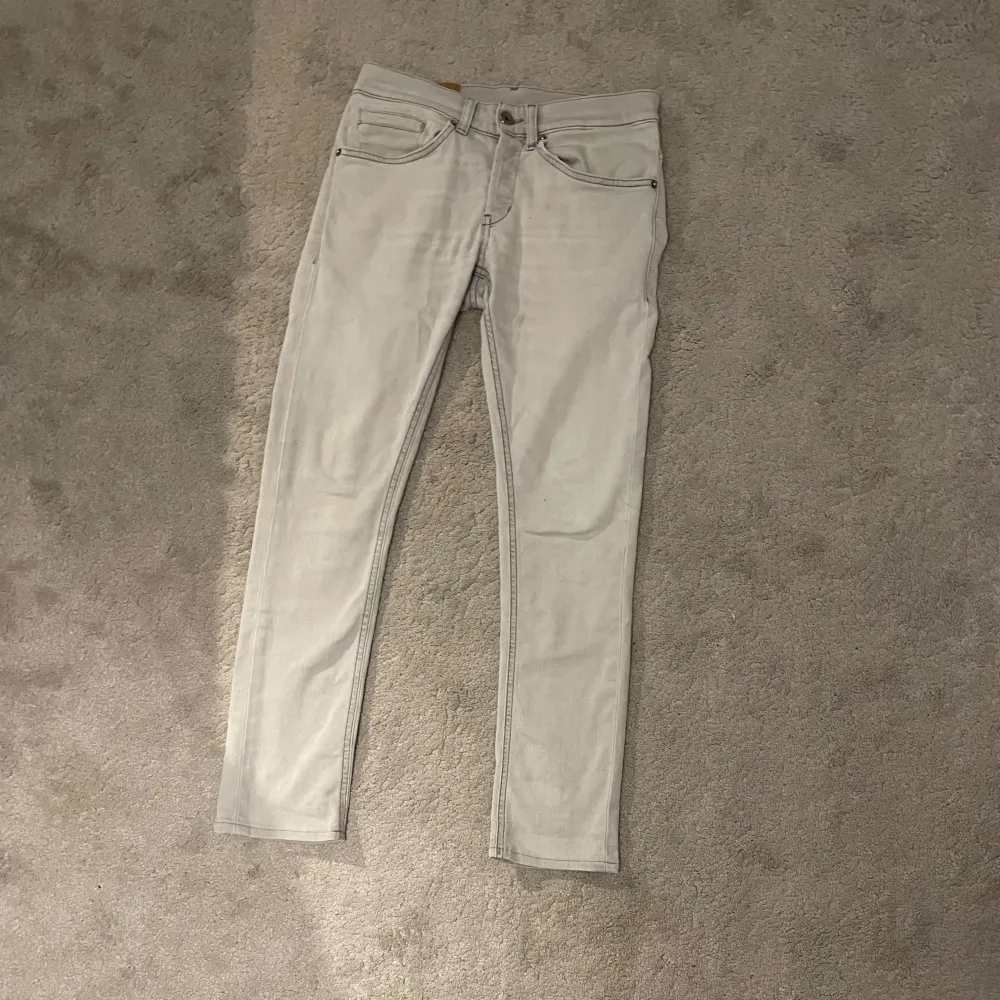 Tja! Säljer dessa ljusgråa Dondup George jeans i storlek W28 men små i storleken å passar dig som är runt 160cm lång, jeansen är i mycket fint skick om man bortser från en pytteliten brun prick på baksidan som knappt märks. Jeansen säljs då de är för tajta för mig. Jeansen är köpta för runt 3000kr. Skriv vid minsta fundering!. Jeans & Byxor.