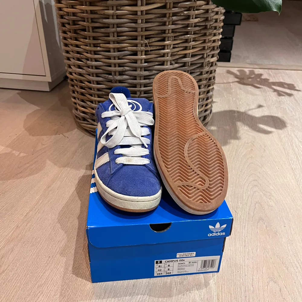 Säljer ett par snygga blå Adidas Campus sneakers i mocka. Perfekt för en casual look. Går att välja vilken snörning man vill ha så fixar jag! (Se bild 2 och 3). Skorna är i nytt skick då de är använda bara ett fåtal gånger och kommer i originalbox, två extrasnören tillkommer. Ny pris ca 1300, finns kvitto, mitt pris: 550, går att sänka vid snabb affär. Det är bara att fråga över minsta lilla fundering!. Skor.