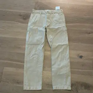 Säljer ett par beige cargopants i bra skick. De har flera praktiska fickor och en avslappnad passform. Perfekta för vardagsbruk eller en avslappnad utflykt. Passar till det mesta och är superbekväma!