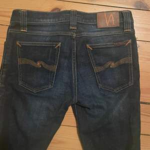 Säljer ett par snygga mörkblå jeans från Nudie i storlek W30 L32