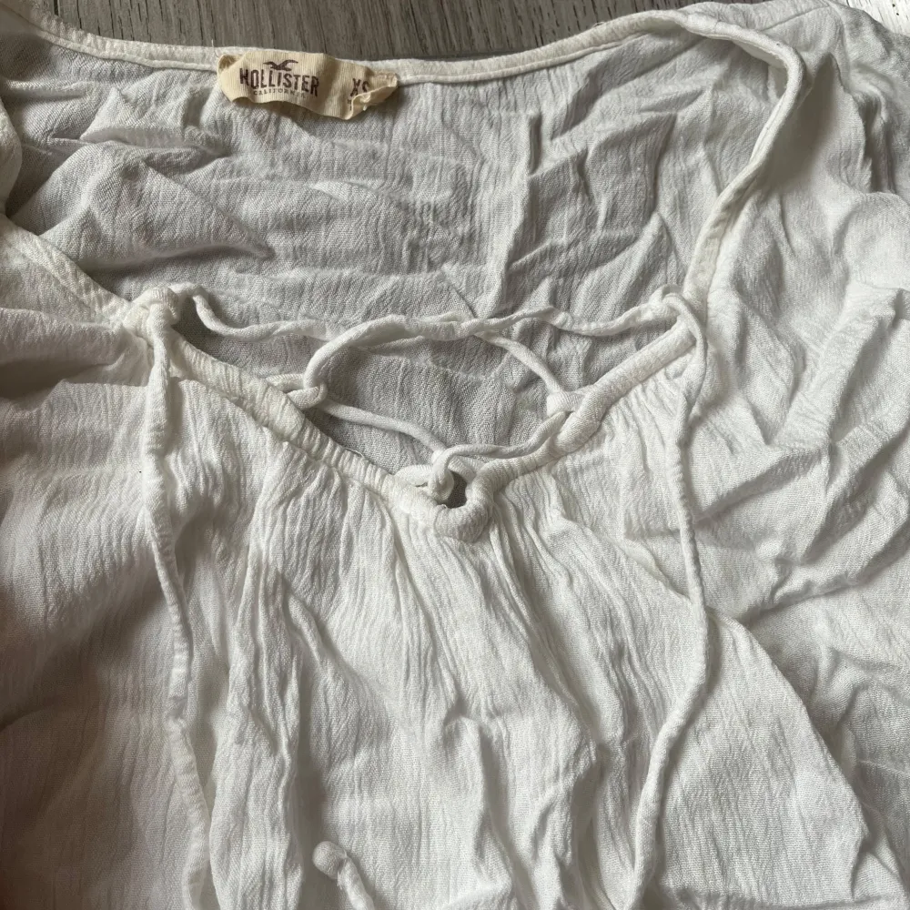 Vit blus med knytning i bysten, från hollister. Utsvängda ärmar med fina detaljer och snörning i bysten. Går utmärkt att styla både casual men också gulligare och finare! Säljer den då den tyvärr är för liten för mig😕 storlek XS. Blusar.