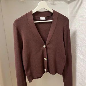 Brun stickad kofta från Noisy May - Jättefin brun tunnare stickad kofta från Noisy May. Säljer då jag tyvärr aldrig använder den. Storlek L men passar mig som S/M i tröjor💕