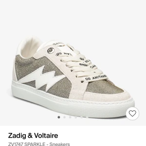 Zadig & Voltaire ZV1747 SPARKLE Sneakers - Snygga sneakers från Zadig & Voltaire i modellen ZV1747 SPARKLE. De har en glittrig yta i silver och beige med vita detaljer. Skorna har snörning och en bekväm sula, perfekt för en trendig vardagslook. Passar bra till både jeans och klänning! Säljer den så dem inte kommer till användning då dem inte riktigt passa min til, (knappt använda ) 