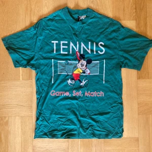 Mörkgrön oversize t-shirt med mussepig  - Mörkgrön oversized t-shirt med tryck av  Disneys mussepig som spelar tennis. Inköpt från h&m, står stl XXS men passar upp till M. Enbart använd fåtal gånger. Klicka gärna på köp nu och meddela för eventuella frågor. :)