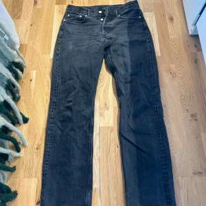 Mörka jeans från Arket - Säljer ett par svarta jeans från Arket i bra skick. De har en klassisk straight fit och är perfekta för både vardag och fest. Passar bra till alla säsonger och kan enkelt matchas med olika outfits.