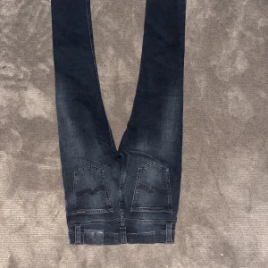 Svarta jeansbyxor - Säljer ett par svarta jeansbyxor i bra skick. De har en slim passform och är perfekta för både vardag och fest. Byxorna har en klassisk design med fem fickor och knappgylf. Perfekta för höst och vinter!