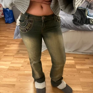lågmidjade jeans med nitar - Snygga jeans från Louis Vuitton med coola nitar och logga på bakfickan. Lite oklar färg men ni ser ju på bilden hur de ser ut. De har en låg midja och en bootcut-stil som ger en retro vibe. 