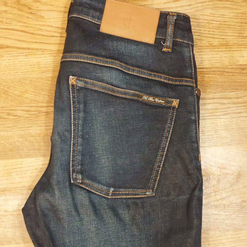 Mörkblåa snyggt solblekta jeans från The Blue Uniform. Nypris 1400kr. Har inga defekter. Jeansen är slim fit och är storlek w32/l34.. Jeans & Byxor.