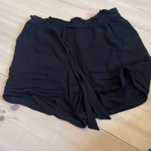 Svarta shorts med knytband - Säljer ett par svarta shorts i bra skick. De har en bekväm loose passform och är perfekta för sommardagar. Shortsen har ett knytband i midjan för justerbar passform. Perfekta för både avslappnade dagar och sommaraktiviteter. 🖤