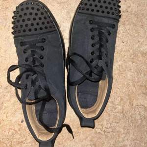 Snygga svarta louboutins med coola nitar på tån och snörning. Perfekta för att ge din outfit en edgy touch. De är i bra skick och passar både till vardags och fest. Skorna har en normal passform och är gjorda i syntetmaterial.