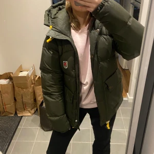 Fjällrävenjacka down expedation lite i mörkgrön  - Säljer en snygg och varm grön dunjacka från Fjällräven. Jackan har en praktisk huva med gula snören och knappar framtill. Perfekt för kalla vinterdagar!  Köpt förra året men ser knappt använd ut, nyskick. Den är i storlek xs och har tyvärr blivit lite för liten för min smak. 💓💓 Hör gärna av dig! 