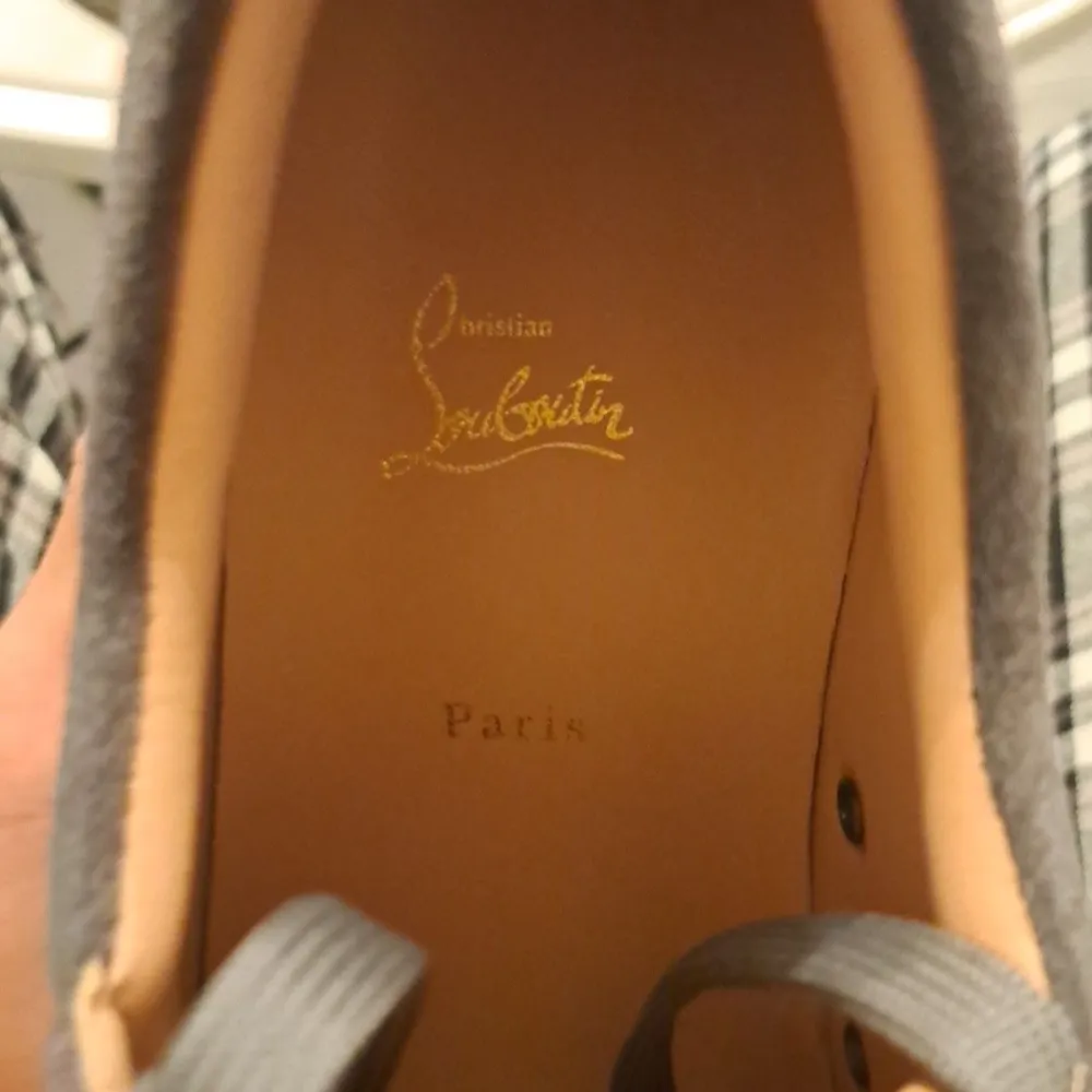 Säljer ett par grå sneakers i mocka från Christian Louboutin. Skorna har coola nitar på tån och den ikoniska röda sulan. Perfekta för att ge din outfit en edgy touch! De är i mycket bra skick och har snörning för en perfekt passform.. Skor.