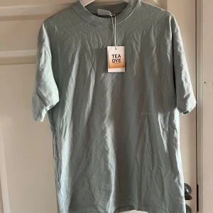 Grön t-shirt från Junkyard - Säljer en stilren grön t-shirt från Yôke ogano tea emb, Junkyard  Den har en normal passform och korta ärmar, perfekt för vardagsbruk. T-shirten är i i nyskick men har lite små fläckar från butik