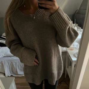 Beige stickad tröja från Carin Wester - Mysig beige stickad tröja från Carin Wester i storlek M. Oversized passform och långa ärmar. Den har en rund halsringning och ribbade muddar. I Kashmir och ull