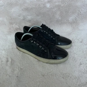 Lanvins - Säljer ett par riktigt feta lanvins i färgen mörkblå i storlek 43. De är i bra skick och enda defekten är det lilla hålet som man ser på bild 3.