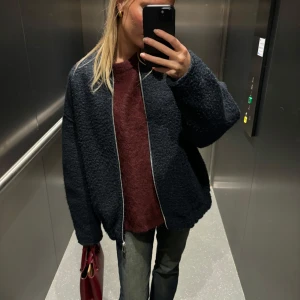 Mörkblå teddyjacka - Säljer en supermysig mörkblå teddyjacka med dragkedja. Perfekt för höst och vinter! Jackan har en oversized passform och långa ärmar, vilket gör den både bekväm och trendig. Den är i mycket bra skick och redo för nya äventyr. Passar perfekt till både vardag och fest! Storlek xs-s