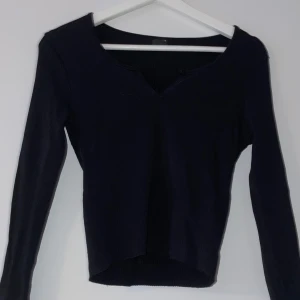 Svart ribbad tröja - Säljer en stilren svart ribbad tröja med v-ringning. Tröjan har långa ärmar och en skön passform som sitter snyggt på kroppen. Ett måste i garderoben för alla säsonger!
