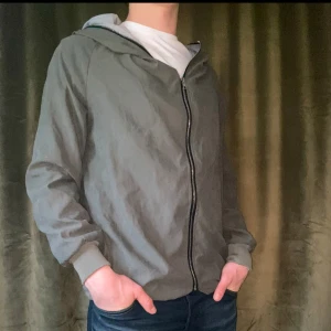 Vindjacka/hoodie - L.B.C. - Säljer en grå hoodie/vindjacka från L.B.C. i storlek M. Den har en dragkedja framtill och en bekväm huva. Perfekt för höst och vår, med en avslappnad passform. Vid minsta fråga eller fundering hör av er🤝