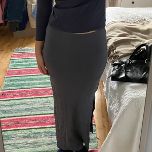 Grå långkjol med slits - Säljer en elegant gråblå långkjol med slits på sidorna som formar sig efter kroppen. 