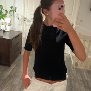 Svart kortärmad topp - Säljer en stilren svart kortärmad topp i ett mjukt material. Perfekt för både vardag och fest. Toppen har en enkel design med rund hals och normal passform. Passar bra till jeans eller kjol för en avslappnad look. Använd endast 1 gång❤️