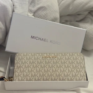 Beige plånbok från Michael Kors - Fin beige plånbok från Michael Kors i mycket bra skick som inte kommer till användning.