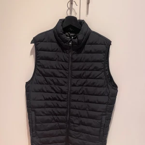 JACK & JONES DUNVÄST - Säljer denna dunväst från Jack & Jones. Säljer p.g.a att den är lite lång för mig och passar dåligt på mig. Västen är helt oanvänd och kommer med etiketten på. Den är i storlek S (Herr).   Om du är intresserad eller har frågor, tveka inte på att höra av dig 😊  Priset kan diskuteras med köparen:)  Nypris: 500 kr