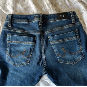 Blå jeans från LTB - Säljer ett par snygga blå jeans från LTB i modellen Valerie. De är i bra skick och har en klassisk femficksdesign med snygga sömmar. Perfekta för vardagsbruk eller en avslappnad utekväll. Passar till det mesta i garderoben!