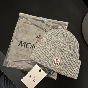Moncler mössa - Grå Moncler mössa helt ny one size. Med tags och påse. Qr kod funkar. Finns i Svart,Vit och Grå