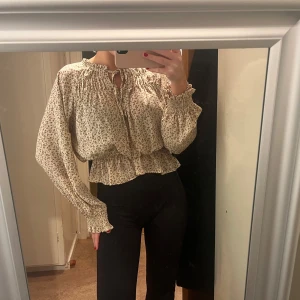 Blommig blus med volangdetaljer - Säljer en superfin blommig blus i beige med små mörka blommor. Tyvär finns det inga lappar kvar i den💕
