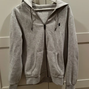 Grå hoodie från Ralph Lauren - Säljer en stilren grå hoodie från Ralph Lauren i mycket bra skick. Säljer för den börjar bli för liten på mig. Storlek S och nypris var 2145. Pris kan diskuteras