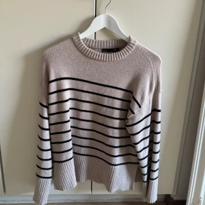 Beige och svart randig tröja - Säljer en snygg beige tröja med svarta ränder. Den är stickad och har en avslappnad passform med långa ärmar och ribbade kanter. Perfekt för höst och vår! 🖤🤍storlek xs