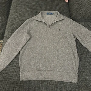 Ralph Lauren half zip - Säljer en stilren grå tröja från Ralph Lauren i mycket bra skick. Den har en dragkedja vid halsen och är perfekt för både vardag och lite finare tillfällen. Tröjan är långärmad och gjord i ett mjukt material som känns skönt mot huden. Passar perfekt till höst och vår! Ny pris 1999kr