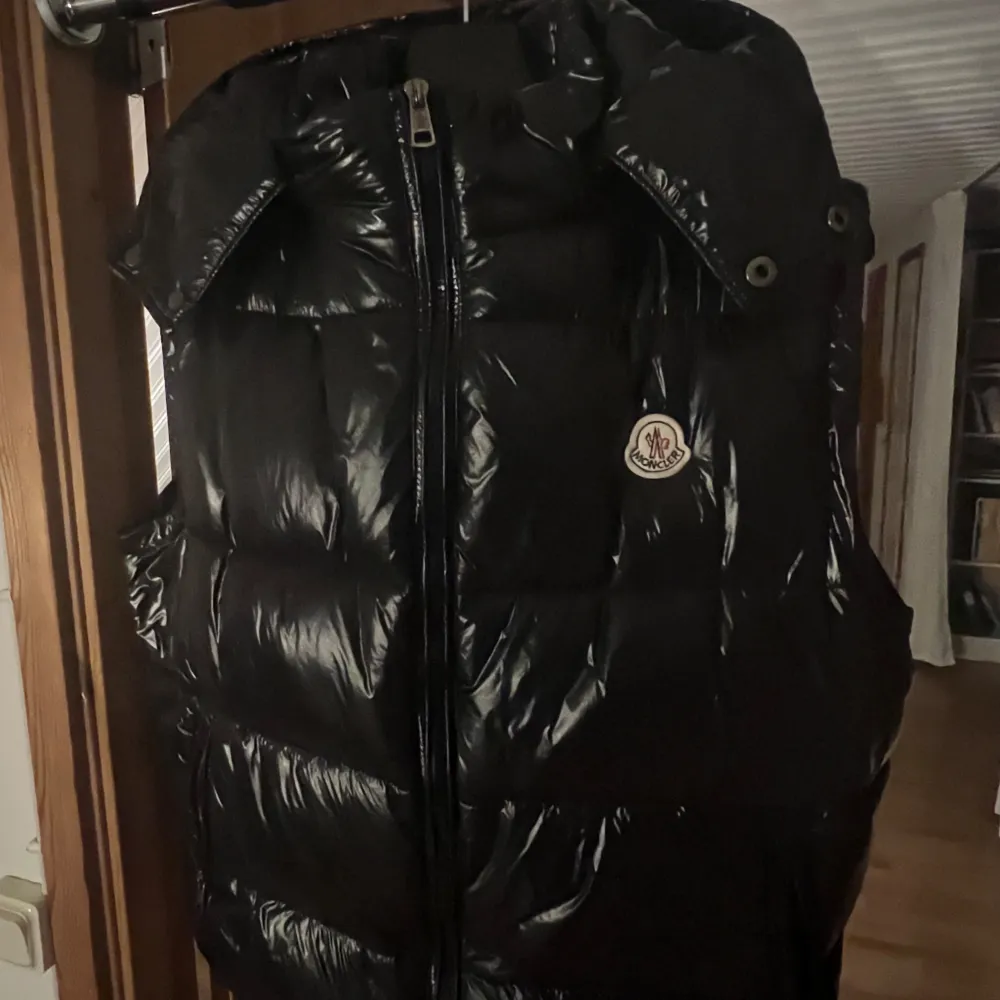 Säljer en snygg svart dunväst från Moncler i mycket bra skick. Västen har en avtagbar huva och dragkedja framtill. Perfekt för höst och vinter, håller dig varm och stilren. Passar både till vardags och festliga tillfällen.. Jackor.