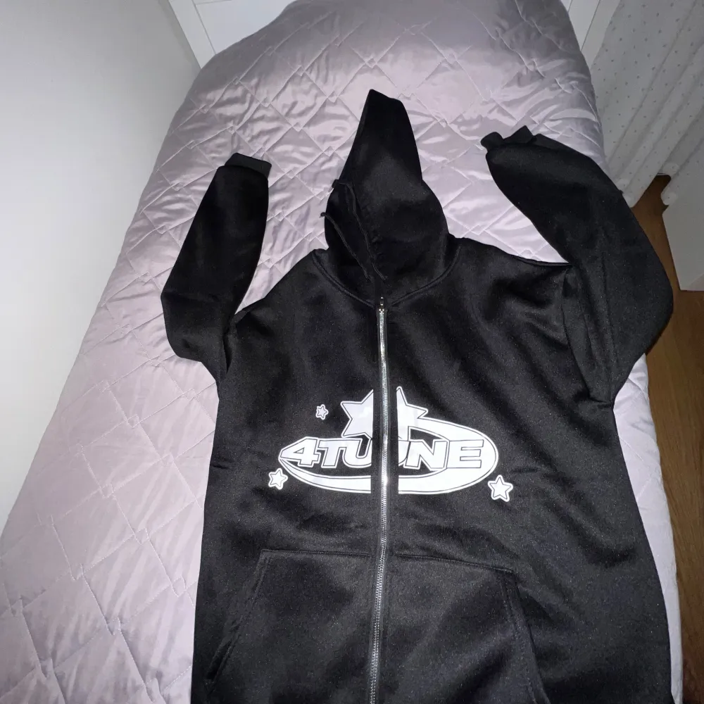 Säljer en svart hoodie med coolt tryck på framsidan. Den har en dragkedja och en stor ficka framtill. Perfekt för höst och vinter, och den är i bra skick. Passar både till vardags och chillkvällar. Hör av dig om du är intresserad!. Hoodies.