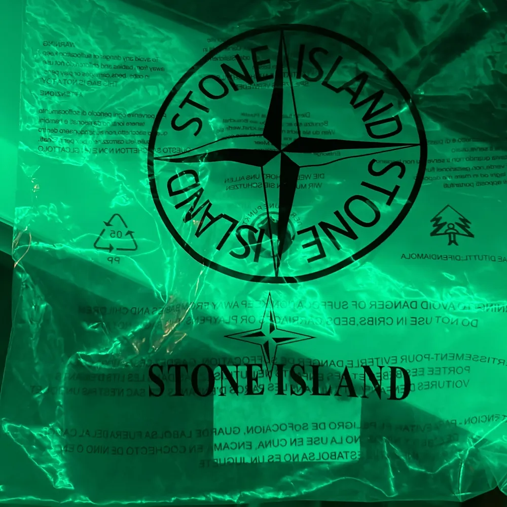 Snygg svart mössa från Stone Island med deras ikoniska logga framtill. Perfekt för att hålla sig varm och stilren under kyliga dagar. Mössan är ribbad och har en klassisk design som passar till det mesta. Ett måste för alla som älskar streetwear! Säljer pga sugen på nåt nytt! Pris ej hugget i sten. Accessoarer.