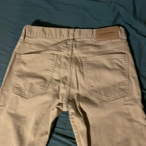 Beige byxor från J.Lindeberg - Säljer ett par väldigt feta beige jeans från J.Lindeberg. De har en klassisk design med fem fickor. Perfekta för både vardag och fest! 🕺