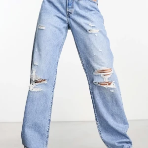 Blå slitna jeans från Levis - 501 90’s med slitningar både fram och på bakficka, rak och avslappnad modell i fint skick! S29L30