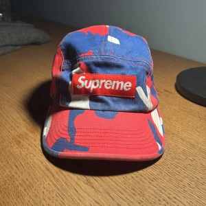 Supreme cap camo - Säljer en fet och nu ganska sällsynt supreme keps i färgen röd, vit och blå. Köptes för 2300kr men säljer för 600kr pga lite användning. Original namnet är Washed chino twill camp cap. Bara att skriva om ni undrar något!