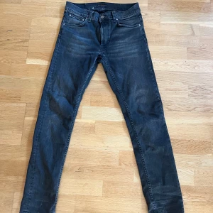 Nudie Jeans, lean dean 30/32 - Gråa Nudie jeans storlek 30/32, litet hål vid skrevet som knappt syns, går att laga gratis i deras butik. Pris kan diskuteras.